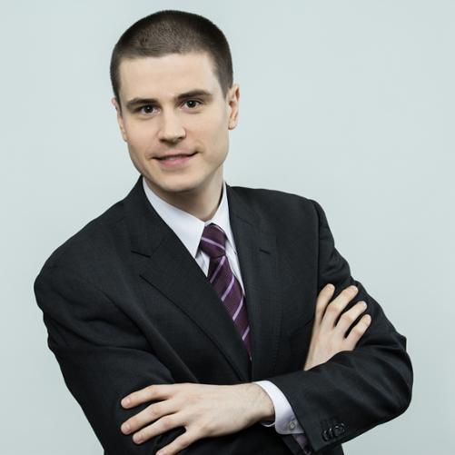 Mężczyzna ubrany w garnitur ze skrzyżowanymi rękami