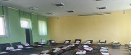Przygotowane miejsca noclegowe w jednostce OSP. Na pierwszym planie rozstawione łóżka polowe.