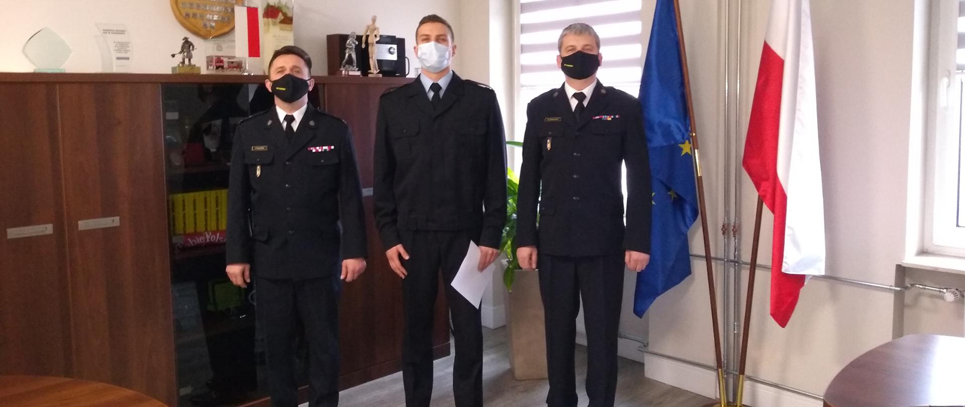 Zdjęcie przedstawia Komendanta Miejskiego,Dowódcę Jednostki Ratowniczo - Gaśniczej oraz nowo przyjętego strażaka.