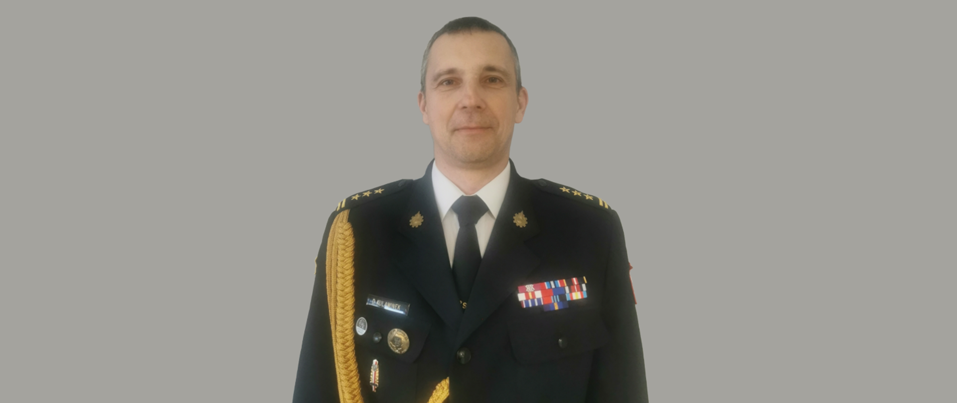 Zdjęcie przedstawia komendanta w mundurze wyjściowym