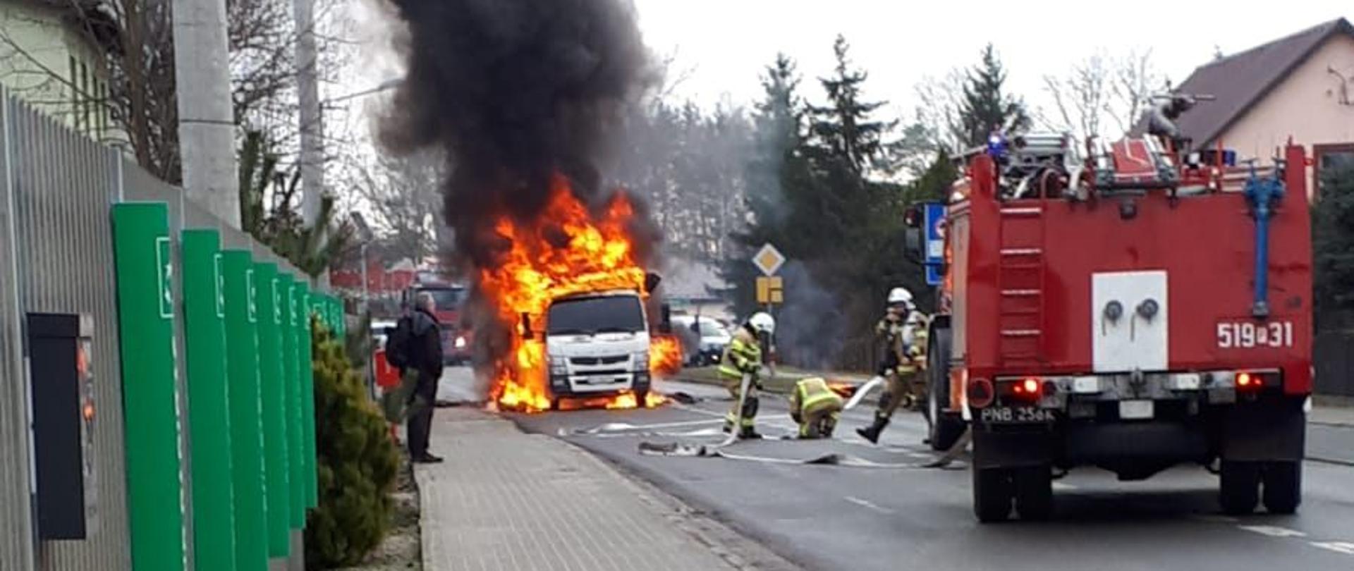 Pożar ciężarówki, strażacy sprawiają sprzęt do gaszenia.