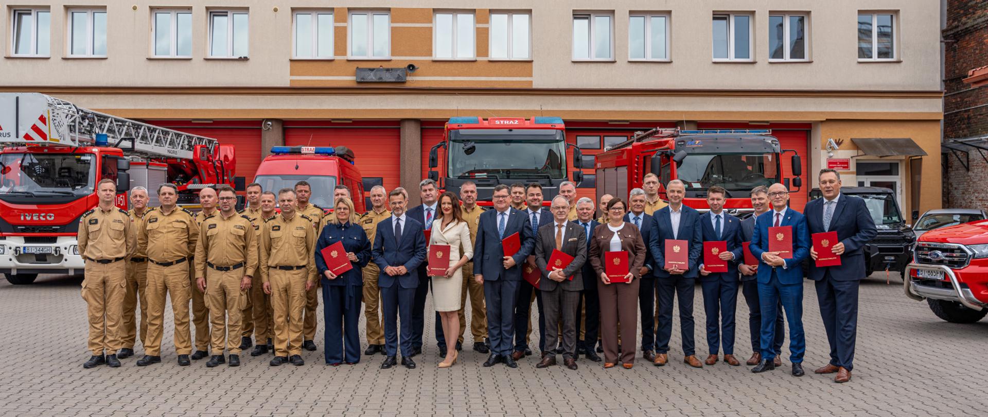 Wojewoda podlaski Jacek Brzozowski podpisał pierwsze umowy ze starostami z województwa podlaskiego. Posłużą one przede wszystkim zaspokojeniu potrzeb krajowego systemu ratownictwa gaśniczego - na zdjęciu wszyscy uczestnicy wydarzenia, kierownictwo KW PSP, i jednostek PSP z terenu woj. podlaskiego, a także wojewoda podlaski i samorządowcy
