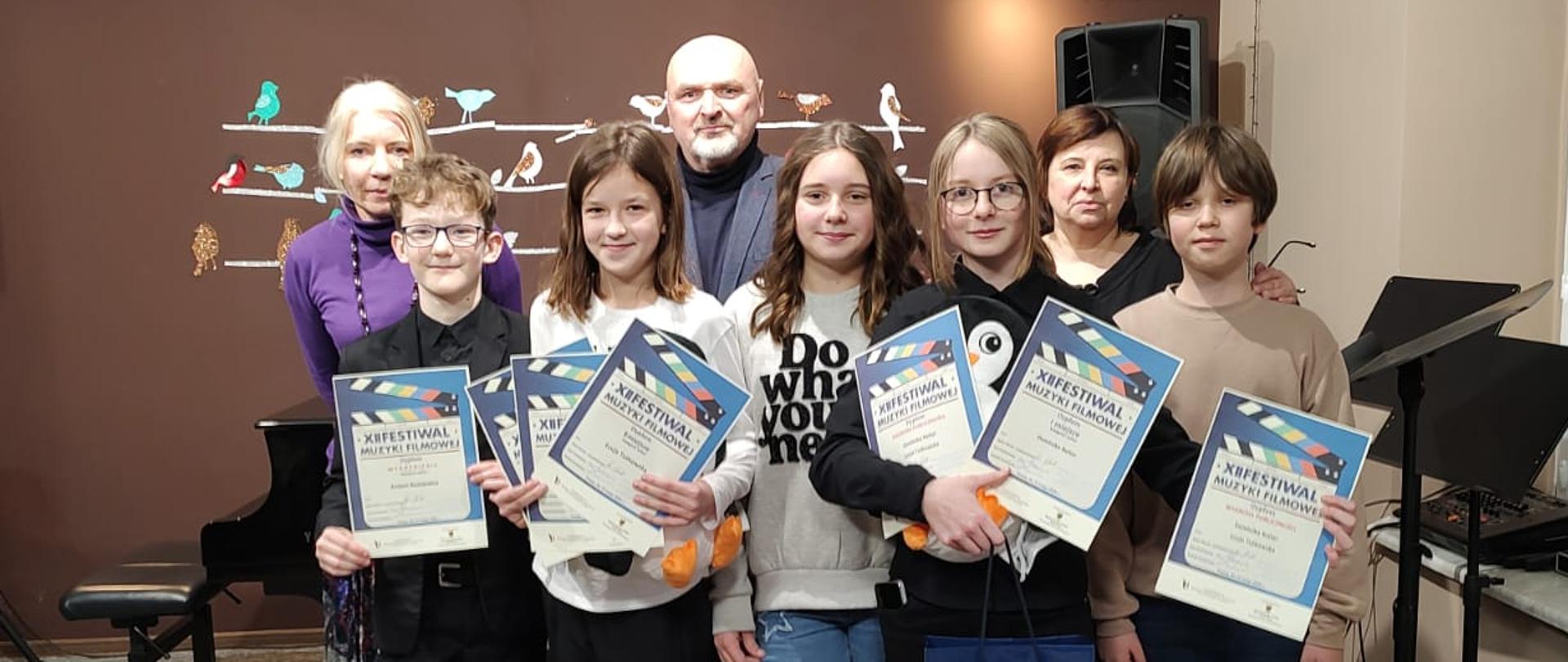 uczniowie trzymający dyplomy