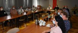 Zdjęcie przedstawia wójtów gmin, komendantów gminnych jednostek ochotniczych straży pożarnych z powiatu łańcuckiego oraz Komendanta Powiatowego Państwowej Straży Pożarnej w Łańcucie siedzących przy stole konferencyjnym na świetlicy Komendy.