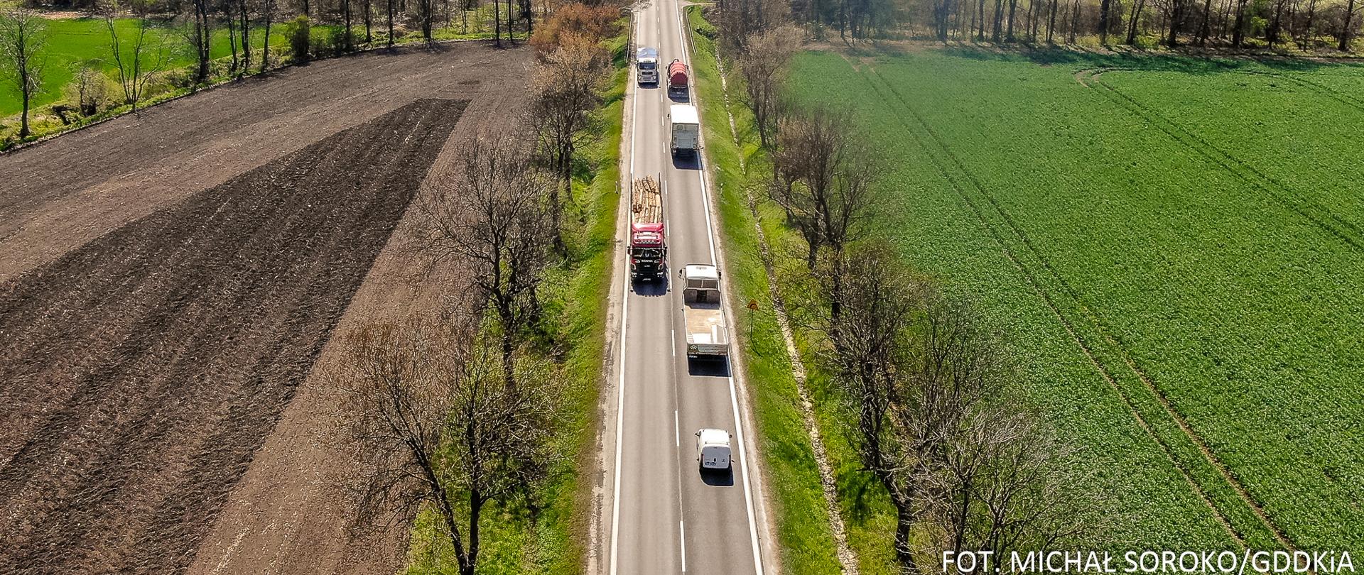 Jednojezdniowa droga, średni ruch samochodów, dookoła pola i łąki, słoneczna pogoda