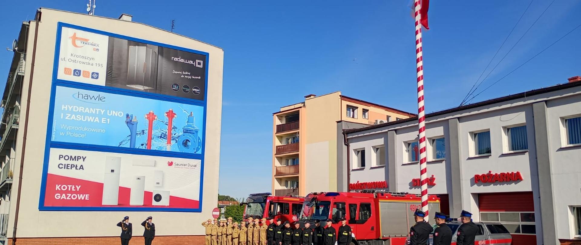 Zdjęcie przedstawia Funkcjonariuszy PSP podczas uroczystego Apelu. Kierownictwo oraz dowódcy pododdziałów oddają honor poprzez salutowanie.
