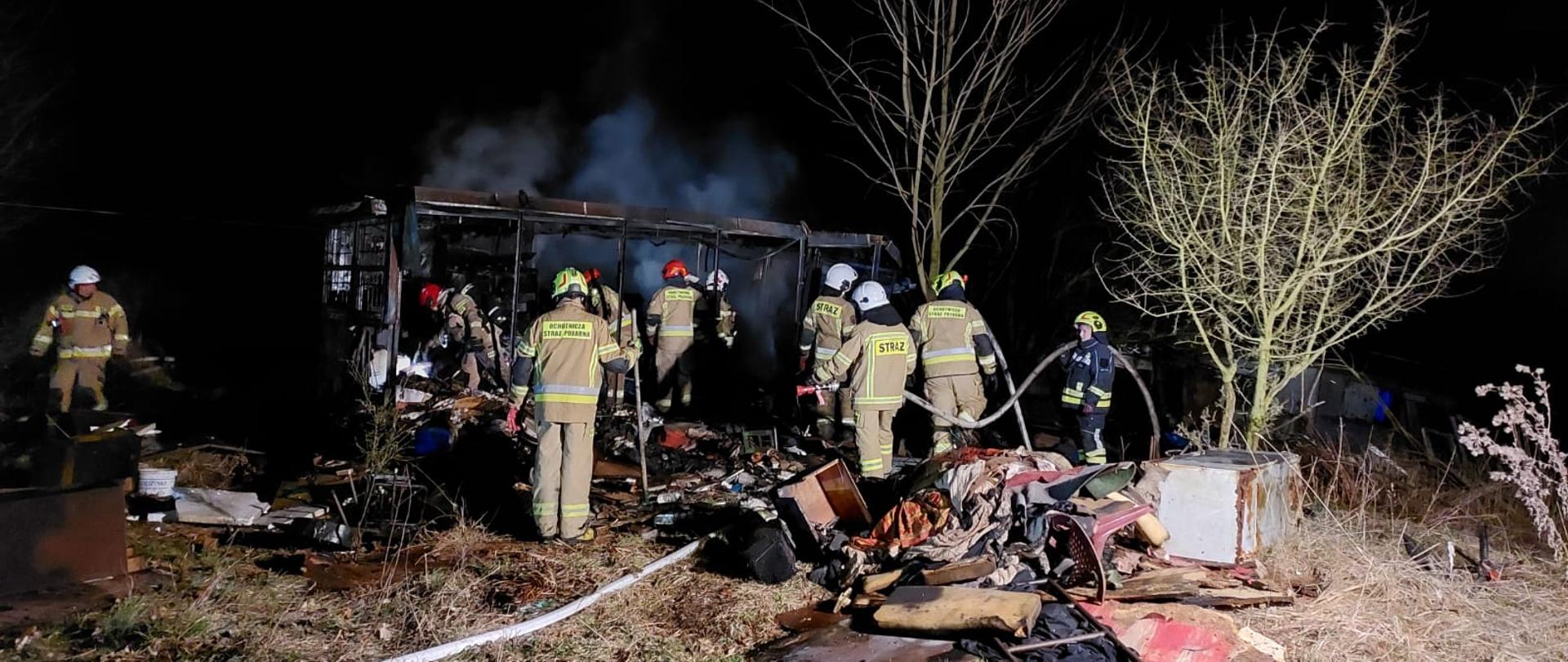 Akcja gaśnicze, strażacy na tle pożaru