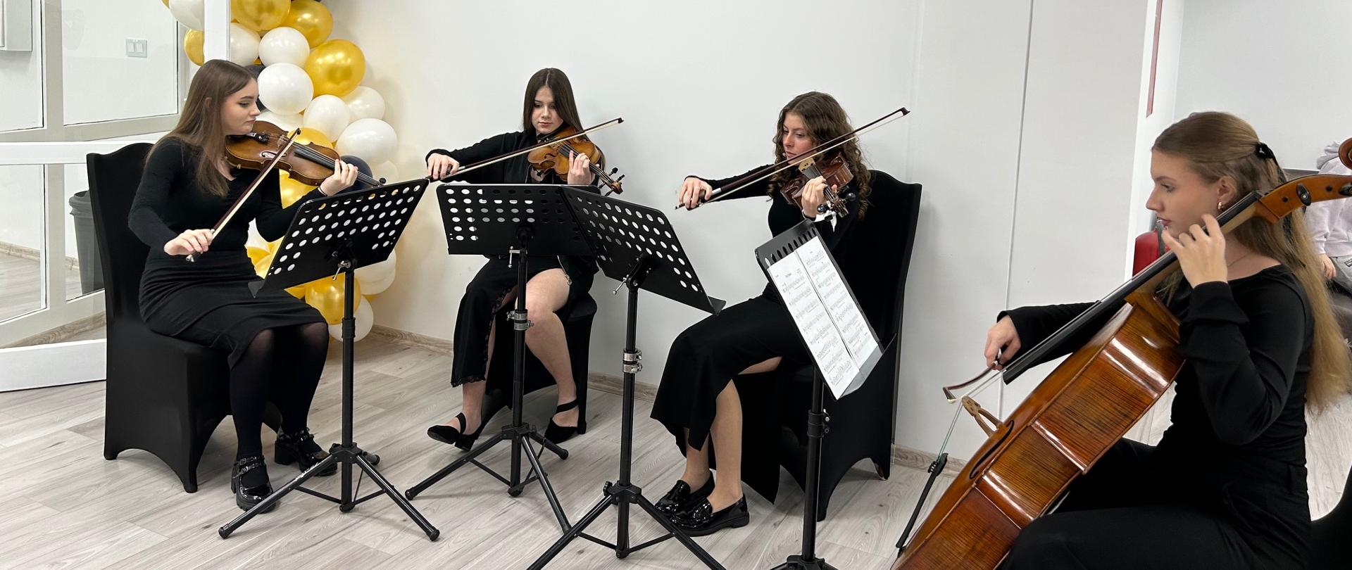 Kwartet smyczkowy PSM II stopnia wykonuje utwór muzyczny podczas wydarzenia w przestrzeni treningowej Pływalni Rekreacyjnej „Smoczka”.