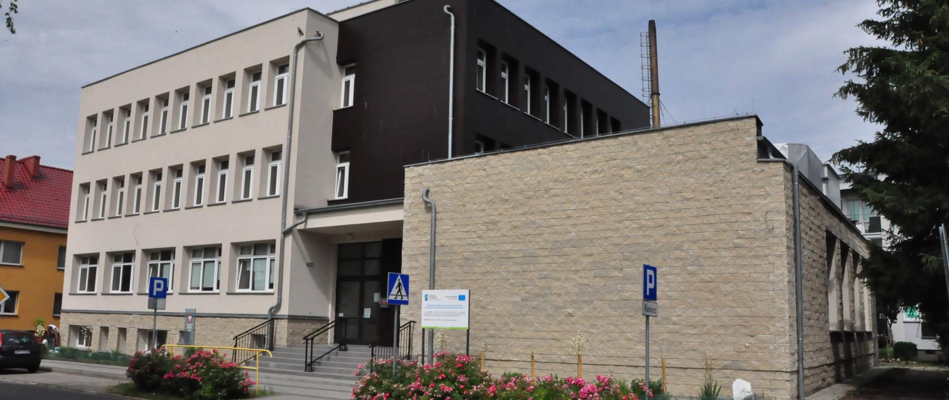 Zdjęcie przedstawia budynek szkoły od strony ulicy Witolda Pileckiego, główne wejście do budynku.