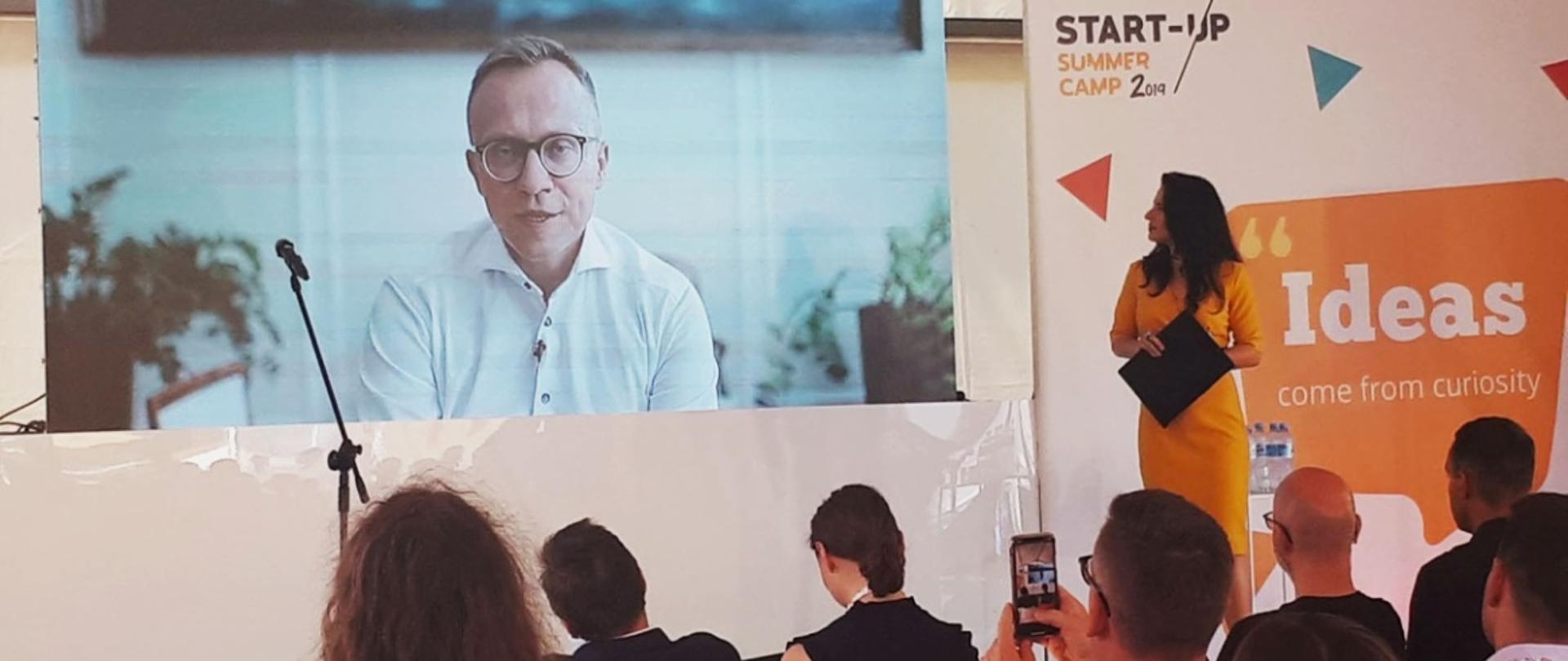 na ekranie wiceminister inwestycji i rozwoju Artur Soboń wita uczestników Start-up Summer Camp