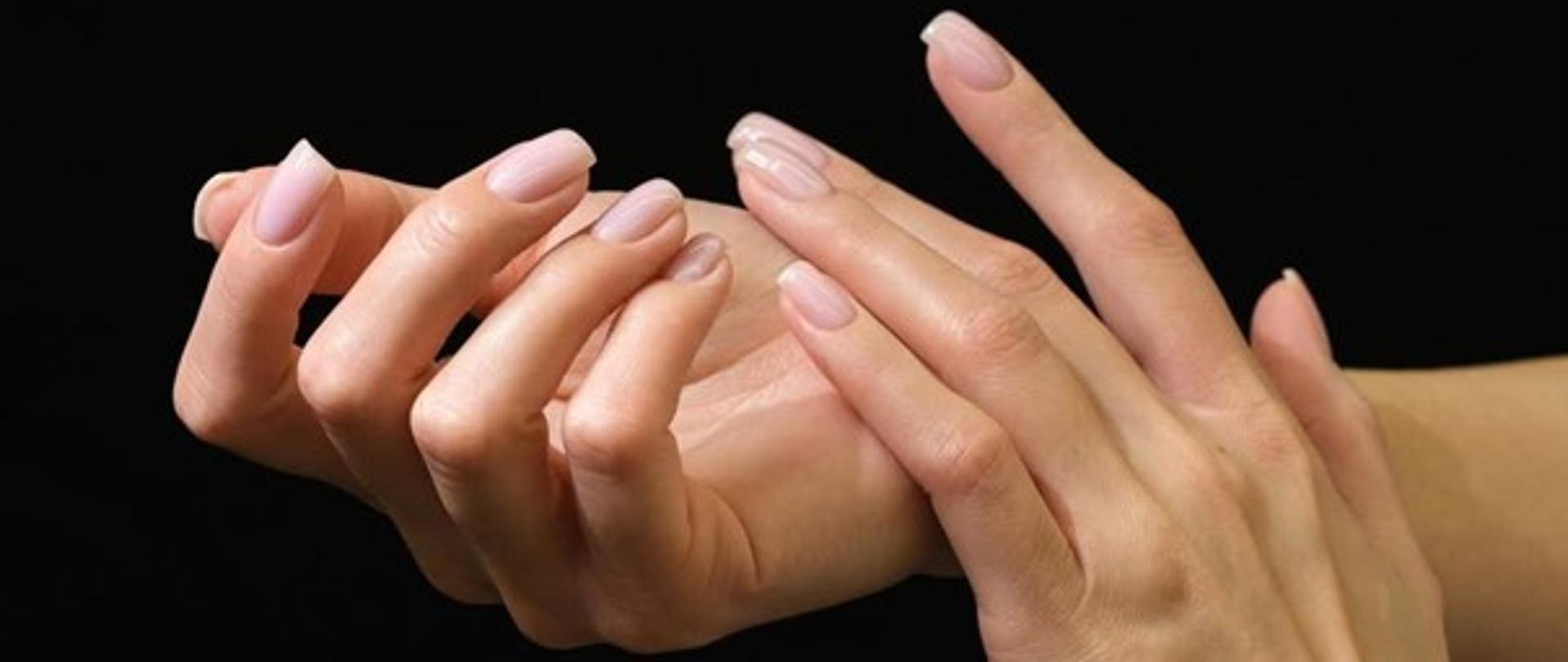 Na zdjęciu znajdują się dłonie. Tło jest czarne.
