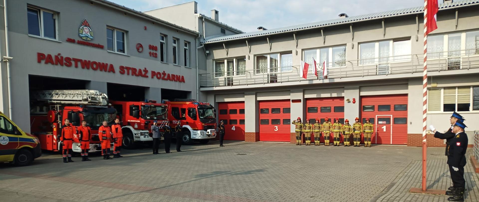 Plac Jednostki Ratowniczo-Gaśniczej w Andrychowie wraz z obsadą jednostki oraz ratownikami medycznymi celebrującymi Święto Dnia Flagi RP.