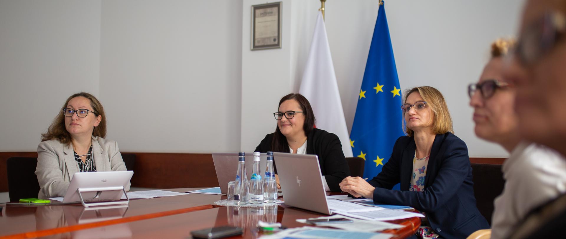 uczestnicy telekonferencji siedzą wokół stołu