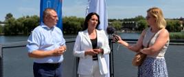 Briefing prasowy Marcina Jarzyńskiego - Zastępcy Prezesa Wód Polskich oraz Hanny Jażdżyk - Członka Zarządu PKP IC podczas pikniku edukacyjnego „Rozpoczęcie wakacji nad Kanałem Augustowskim” na Błoniach rzeki Netty w Augustowie