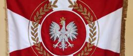 Na zdjęciu widzimy sztandar koloru biało-czerwonego, na krawędziach ozdoby koloru złotego. Na środku sztandaru na czerwonym tle widzimy godło Polski, białego orła w złotej koronie. Wokół godła państwowego na tle czerwono białym widzimy złote liście. W dolnej części sztandaru złoty napis: "BOGU I OJCZYŹNIE" .