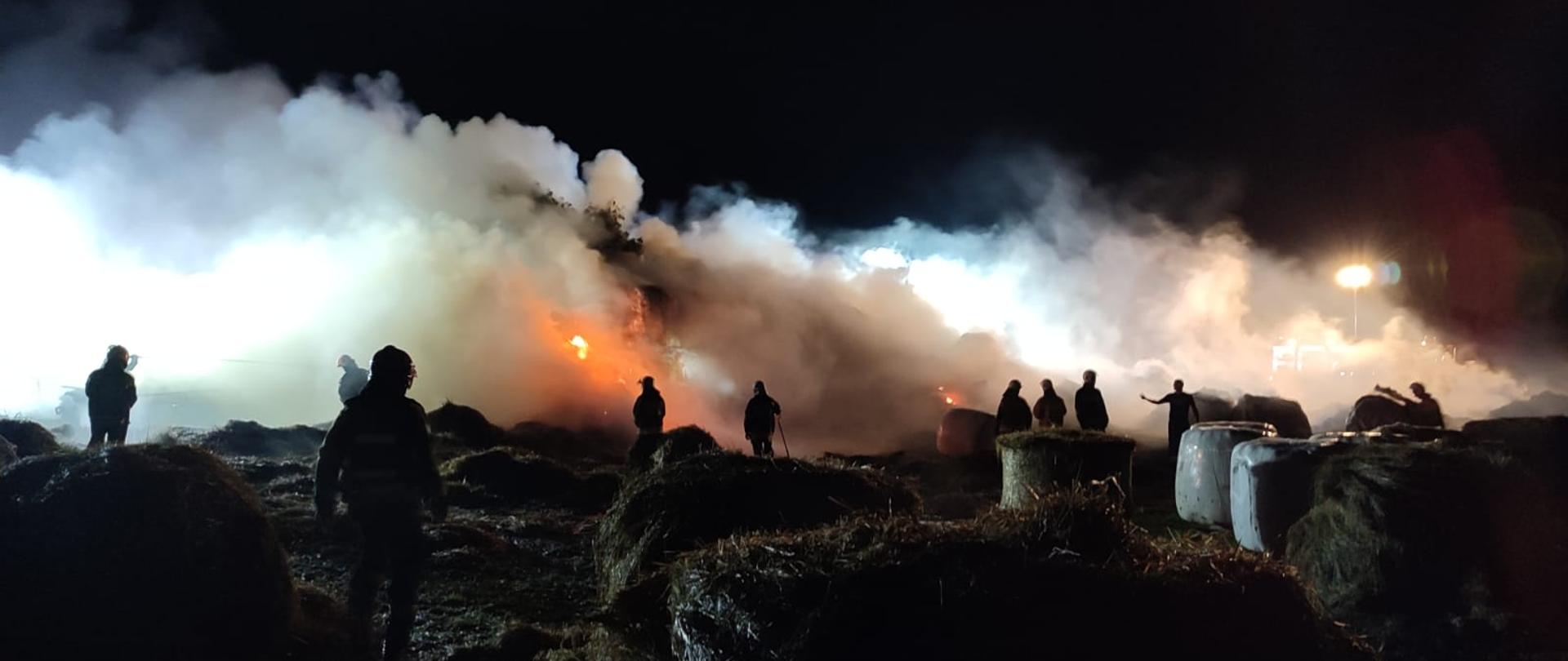 Strażacy gaszą pożar bel siana
