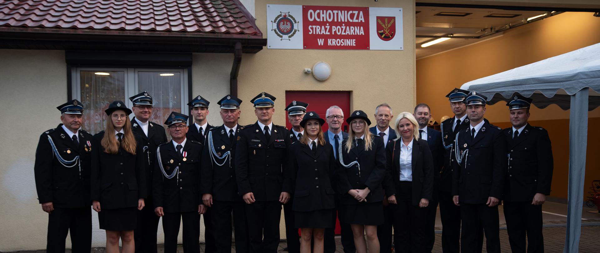 Wspólne zdjęcie panoramiczne druhów z Ochotniczej Straży Pożarnej, Samorządowców i Komendanta Powiatowego Państwowej Straży Pożarnej w Czarnkowie na remizy strażackiej w Krosinie.