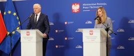 Wicepremier i minister rozwoju, pracy i technologii Jarosław Gowin stojący przy mównicy na konferencji prasowej, po jego prawej stronie wiceminister rozwoju, pracy i technologii Anna Kornecka, za ich plecami baner z logo MRPiT i napisem "Plan dla Pracy i Rozwoju" oraz flagi Polski i UE
