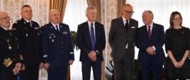 Przedstawiciele służb mundurowych oraz zaproszeni goście stoją obok siebie.