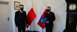 Zdjęcie przedstawia zastępcę pomorskiego komendanta wojewódzkiego PSP st. bryg. Tomasza Siemiętowskiego wręczającego podziękowanie komendantowi powiatowemu PSP w Kwidzynie mł. bryg. Wojciechowi Berent za zaangażowanie w organizację ćwiczeń ratowniczych.