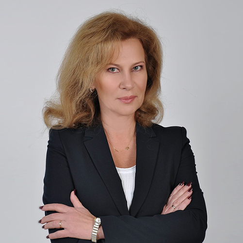 Kobieta o jasnobrązowych włosach ubrana w czarną marynarkę i białą bluzkę.