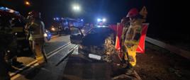 Zdjęcie przedstawia rozbity pojazd osobowy marki Volkswagen Golf. Droga krajowa nr 92, warunki nocne. Zniszczenia pojazdu świadczą, że uderzenie w pojazd ciężarowy nastąpiło od strony kierowcy, który niestety zginął w wypadku. Na zdjęciu strażacy prowadzący czynności ratownicze.