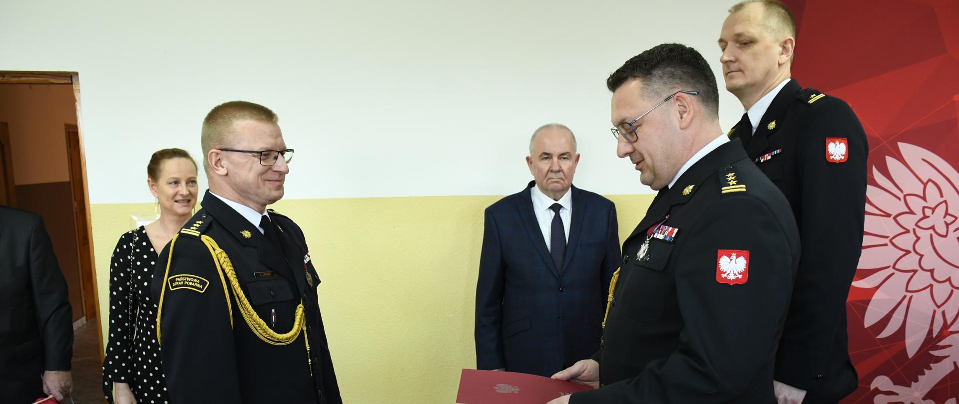 Zastępca Warmińsko-Mazurskiego Komendanta Wojewódzkiego st. bryg. Tomasz Ostrowski wręcza decyzję st. bryg. Adamowi Zarębie