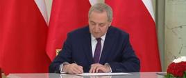 Minister Henryk Kowalczyk składa podpis pod rotą przysięgi (fot. KPRM)