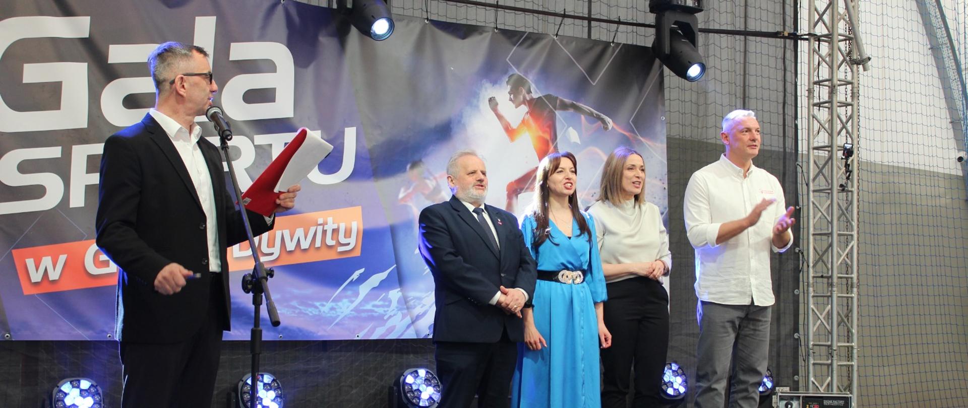 Na scenie prowadzący galę i goście, wśród nich wicewojewoda Zbigniew Szczypiński.