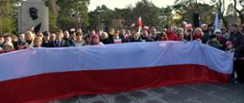 Na zdjęciu uczestnicy uroczystości odzyskania dnia niepodległości trzymający flagę narodową.