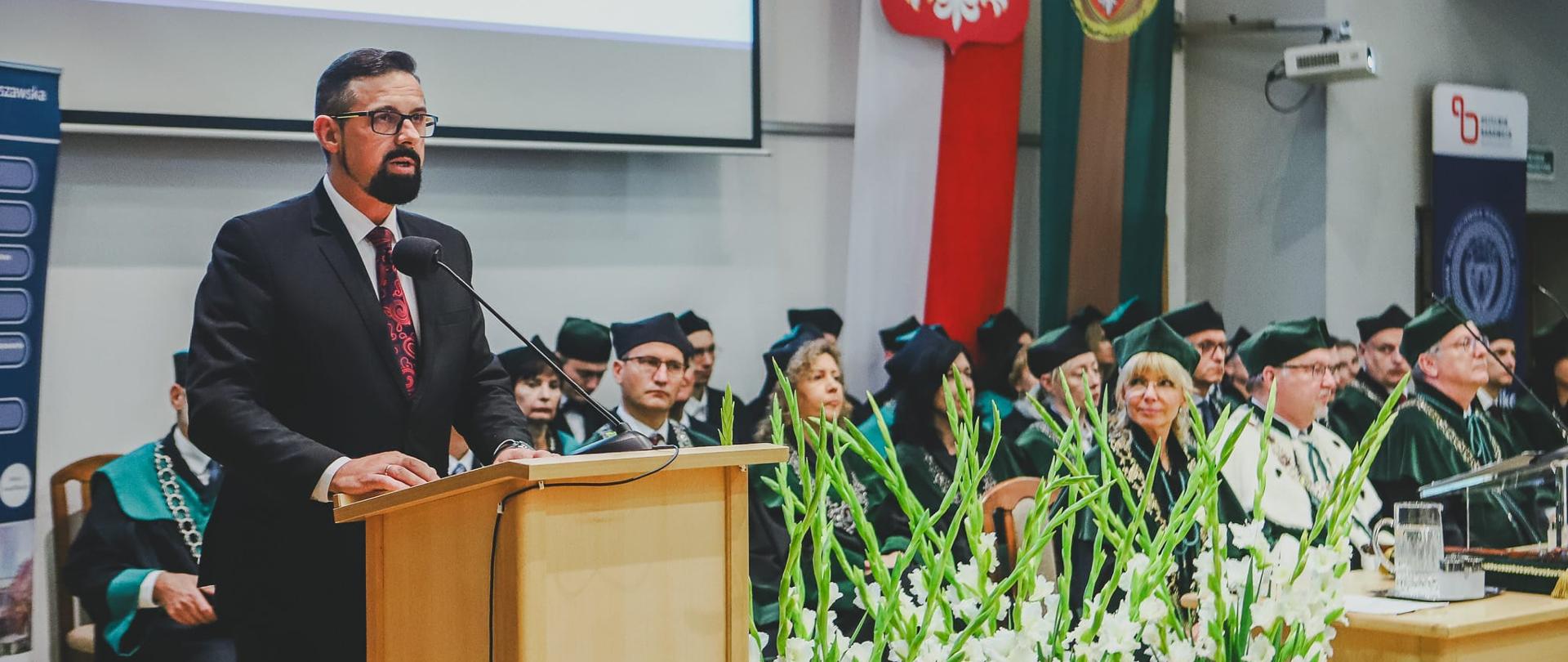 Na zdjęciu widać mężczyznę przy mównicy