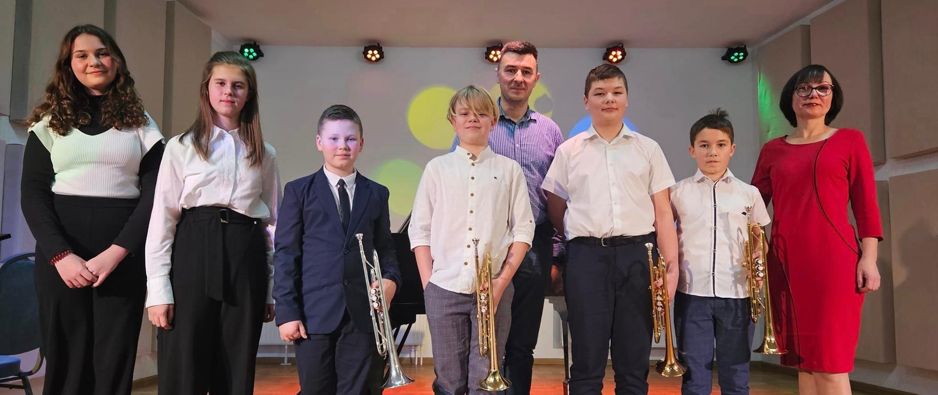 Uczniowie klasy trąbki i akordeonu po zakończonej audycji na szkolnej scenie. 