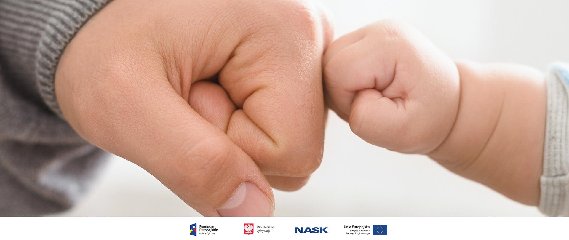 Stykające się pięści: osoby dorosłej i dziecka, w bliskim ujęciu