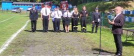 bieżnia boiska sportowego-stojący przed mikrofonem starosta powiatu, w tle sędziowie zawodów w mundurach