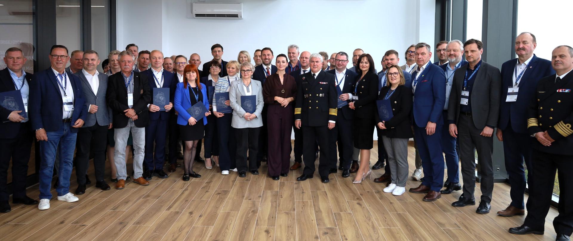 grupa kilkudziesięciu osób pozuje do zdjęcia