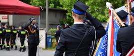 Pododdziały Państwowej i Ochotniczych Straży Pożarnych oraz Poczty Sztandarowe podczas defilady. na pierwszym planie druh OSP (tyłem do aparatu) który idzie wraz z pododdziałem w szyku i oddaje honor dowódcy uroczystości