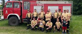 Zdjęcie przedstawia druhów OSP Wołowe Lasy z pucharem i dyplomem, na tle samochodu pożarniczych