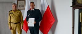 Pomorski komendant wojewódzki PSP stoi z wyróżnionym strażakiem Państwowej Straży Pożarnej.