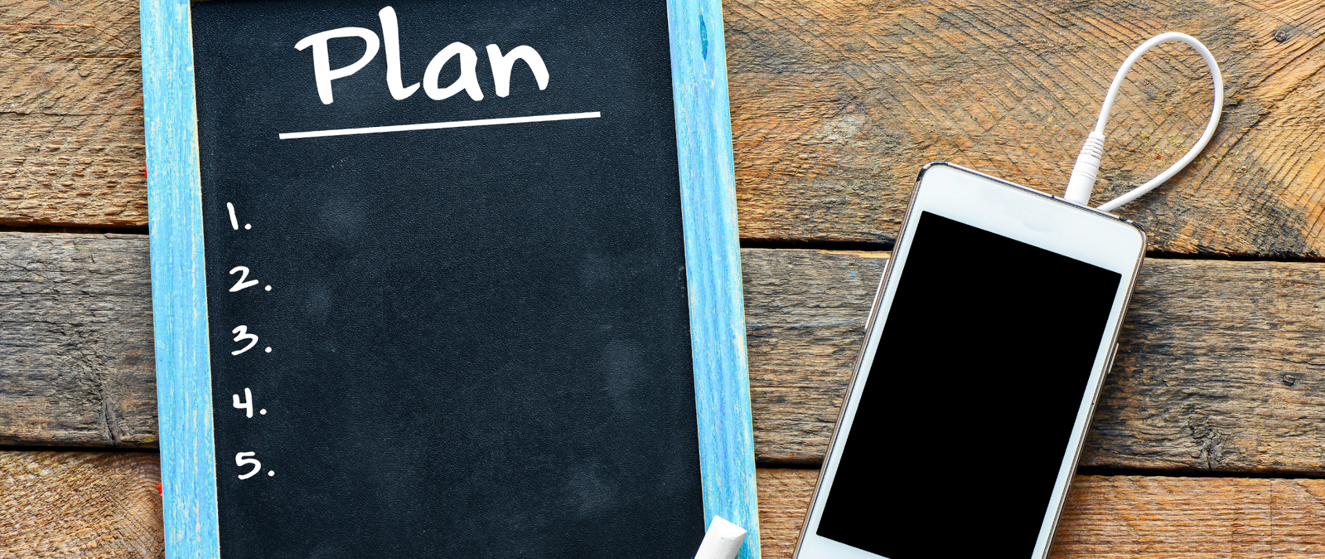 Tablica kredowa z napisem "1. 2. 3. 4. 5.", obok telefon z wpiętymi słuchawkami