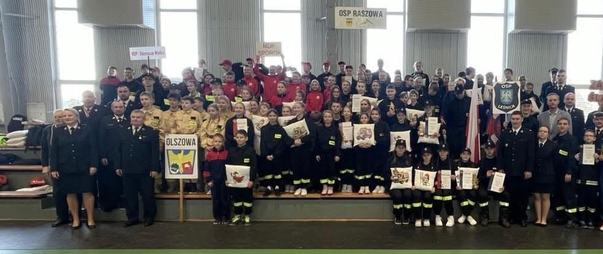 Na zdjęciu znajdują się dzieci i osoby dorosłe ustawione do wspólnego zdjęcia