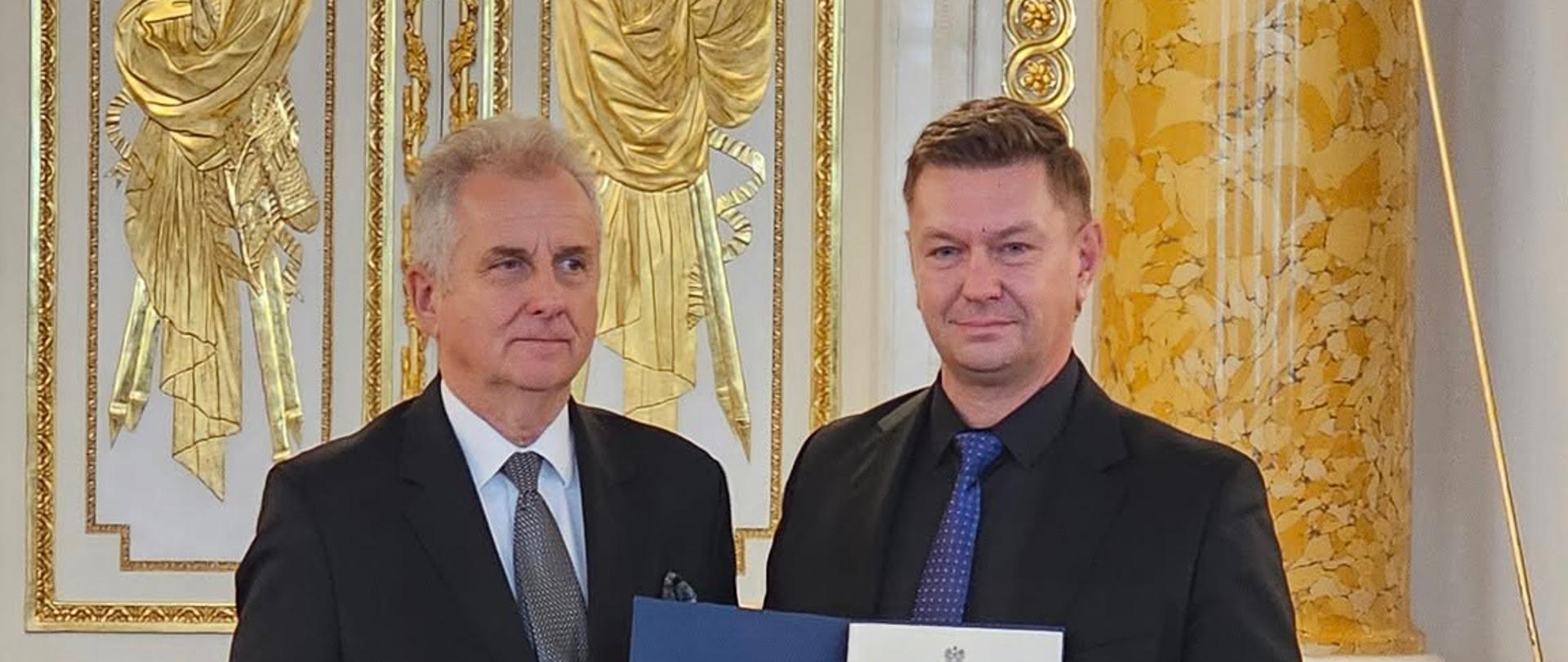 zdjęcie przedstawia mężczyzn w garniturach na tle eleganckiego wnętrza