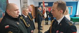 Na zdjęciu widać Komendanta powiatowego PSP dziękującego emerytom 