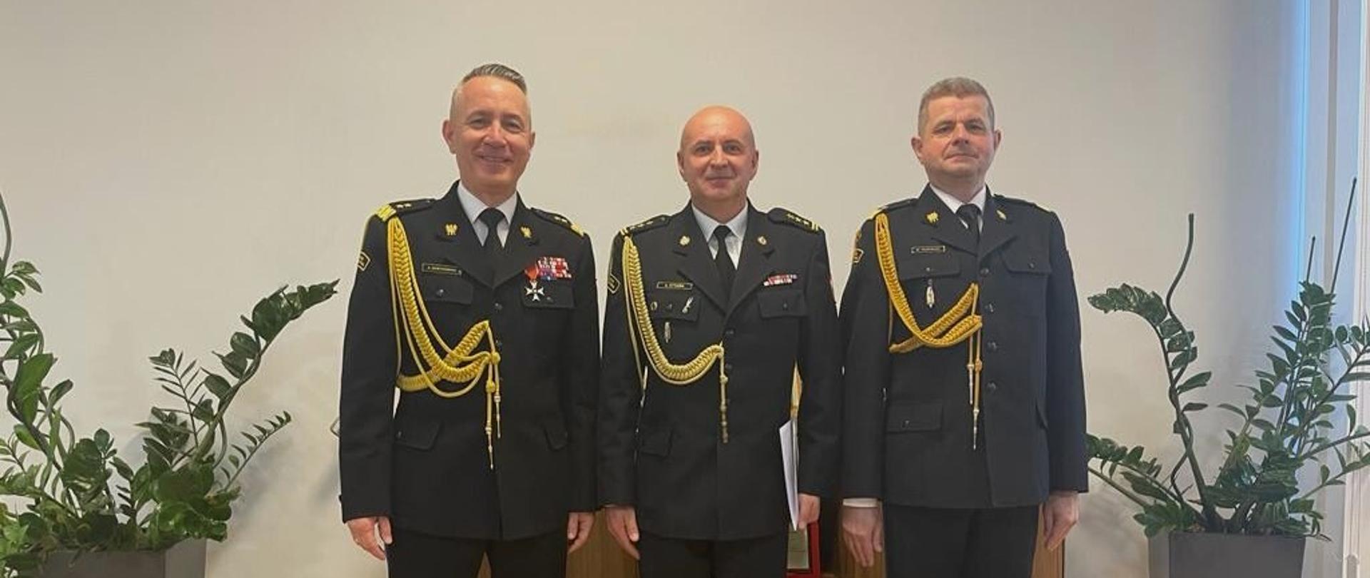 (od lewej strony) komendant główny PSP, zastępca dolnośląskiego k-ta wojewódzkiego i dolnośląski komendant wojewódzki pozują do zdjęcia