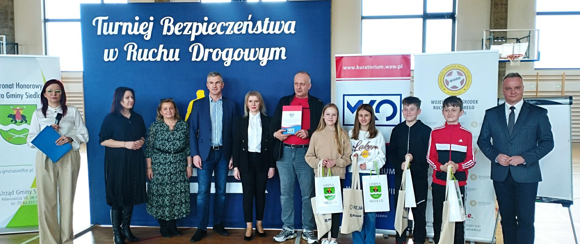 Na zdjęciu grupa osób - dzieci i dorosłych z wręczonymi nagrodami. 