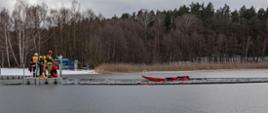 Na zdjęciu widać strażaków podczas ćwiczeń na zamarzniętym jeziorze.