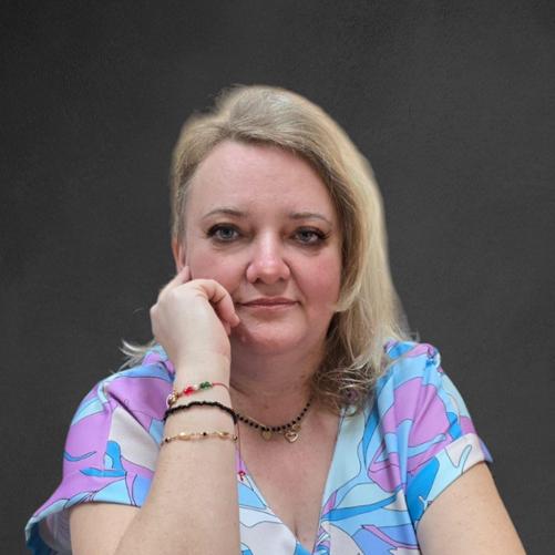 Zdjęcie przedstawia portret Kierownika Wydziału Organizacyjno-Administracyjnego, Panią Agnieszkę Spiżak, ubraną w kolorową bluzkę w niebieskie, beżowe i różowe wzory.