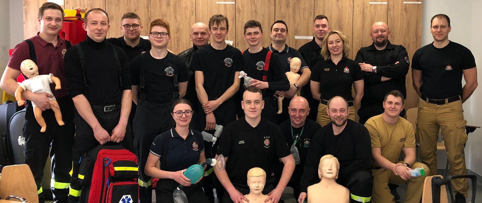 Wspólne zdjęcie kursantów i wykładowców na sali zajęciowej Ośrodka Szkolenia Komendy Wojewódzkiej Państwowej Straży Pożarnej. Kurs kwalifikowanej pierwszej pomocy.