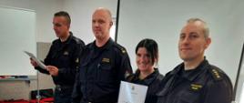 Zdjęcie przedstawia mł. bryg. Grzegorza Falkowskiego, Zastępcy Komendanta Miejskiego PSP w Słupsku, st. kpt. Krzysztofa Bizona, Dowódcy JRG nr 2 w Słupsku oraz mł. kpt. Piotra Basaraba, Naczelnika Wydziału Operacyjno-Szkoleniowego KM PSP w Słupsku oraz uczestniczkę kursu