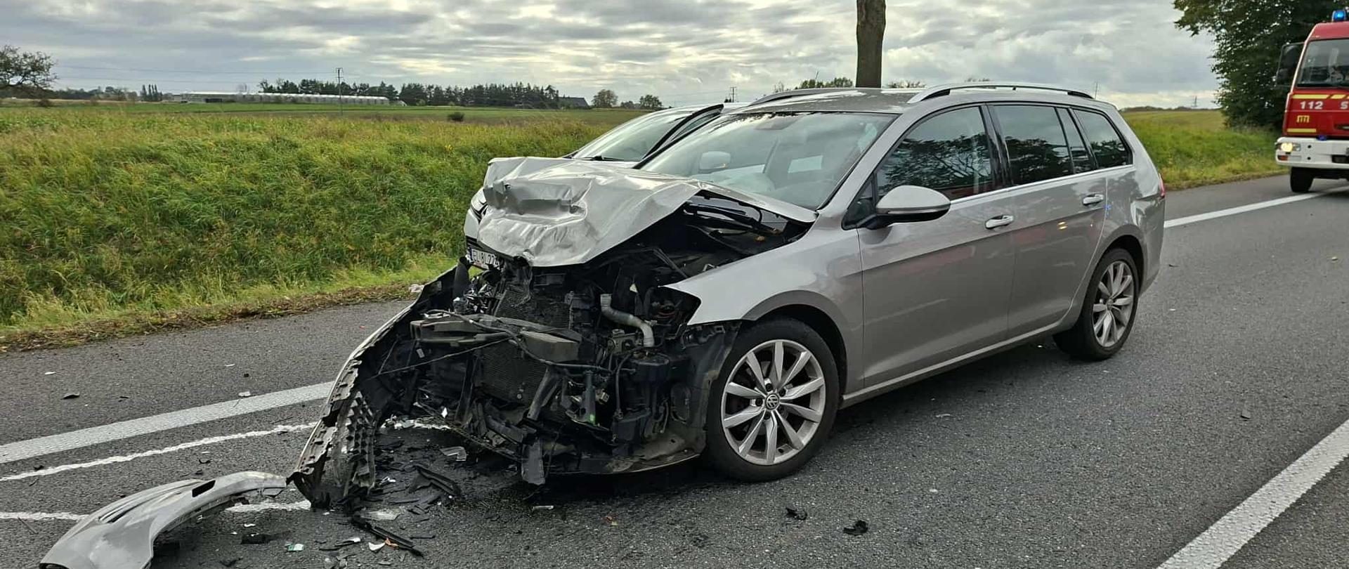 Popielaty samochód z uszkodzonym przodem na drodze