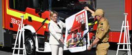 Minister Anna Moskwa wraz z Komendantem Głównym PSP prezentują plakat "Bitwa o remizy"